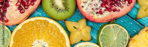 Colorful fruit slices on blue wood surface