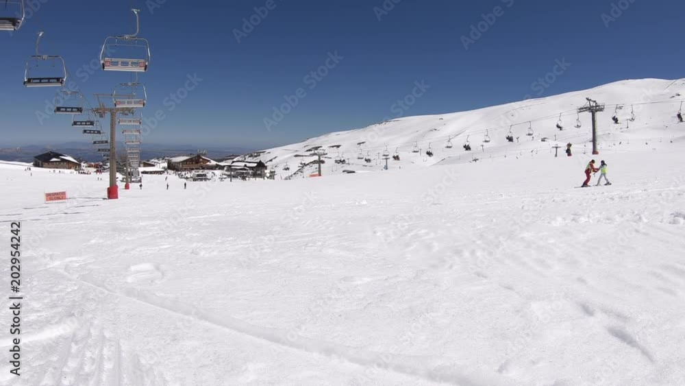 4K. Ski resort in Sierra Nevada, Spain. The chairlift is stopped. There are people doing skiing and snowboarding in the surroundings-Adrian. 4K. Ski resort in Sierra Nevada, Spain. The chairlift is stopped. There are people doing skiing and snowboarding in the surroundings-Adrian.