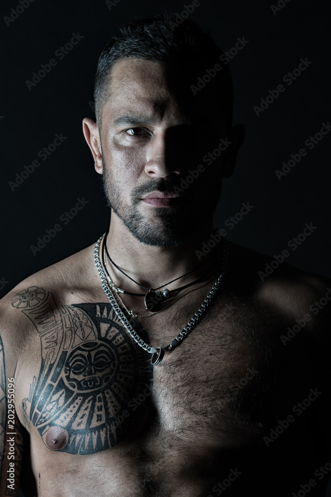 Bearded man with tattooed chest. Macho with sexy bare torso. Fit model with  tattoo art on skin. Sportsman or athlete with stylish beard and hair. Sport  and fitness. Confidence and masculinity Stock