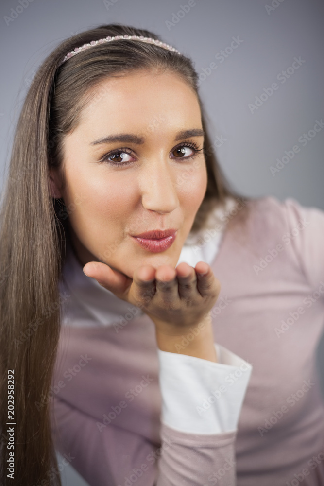 Pretty model with pink dress on kissing at camera Pretty model with pink dress on kissing at camera