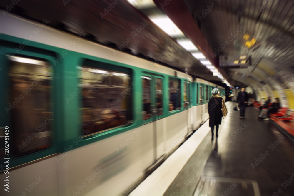Blurry motion image of woman walking in a subway station. Train approaches. Lifestyle and culture concept Blurry motion image of woman walking in a subway station. Train approaches. Lifestyle and culture concept
