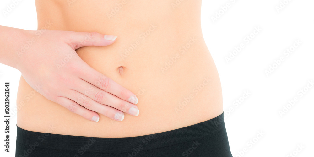 Closeup mid section of a fit young woman with stomach pain over white background