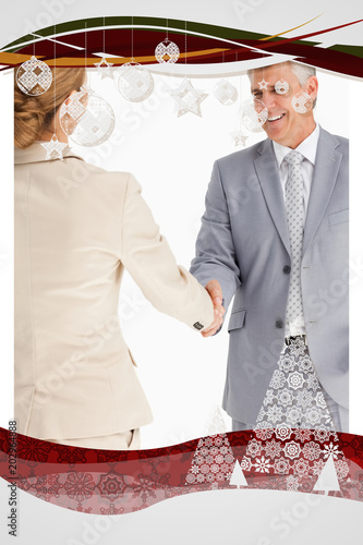 Happy business people shaking hands against christmas frame photo