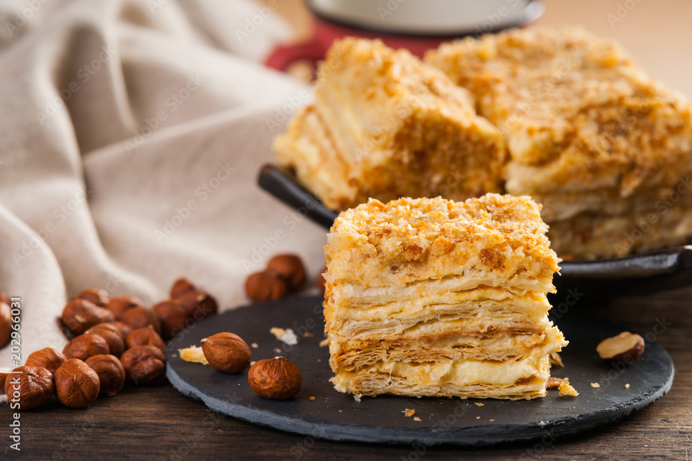 Slice of sweet classic layered cake Napoleon and hazelnuts Slice of sweet classic layered cake Napoleon and hazelnuts