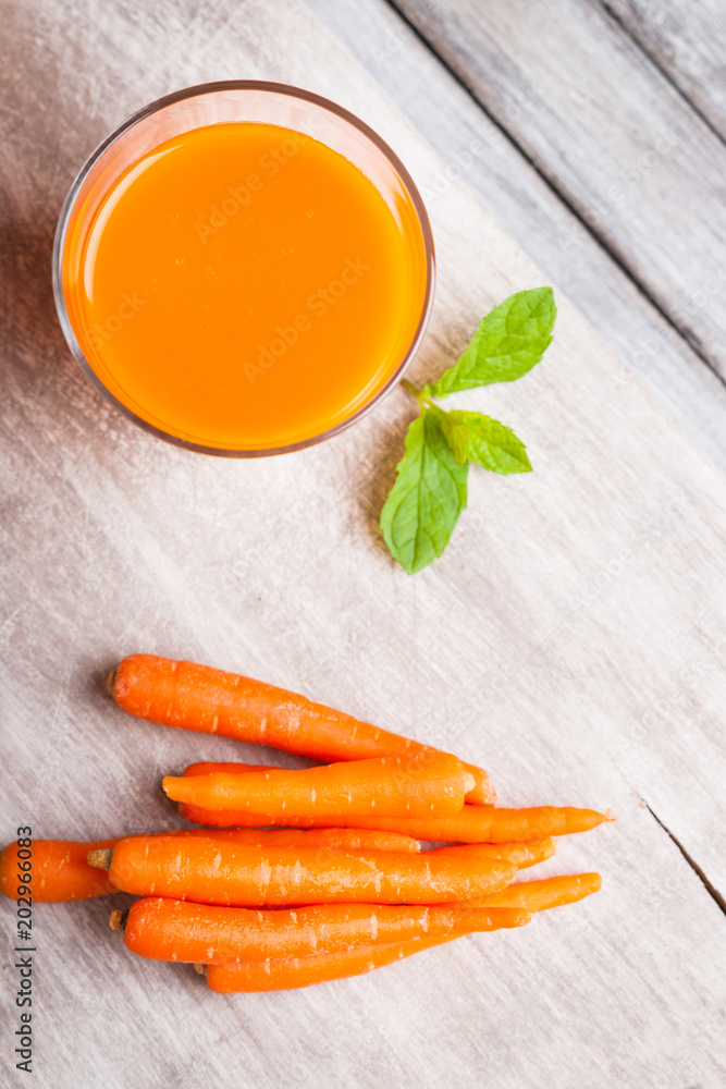 Glass with carrot juice, carrot and mint leaf Glass with carrot juice, carrot and mint leaf