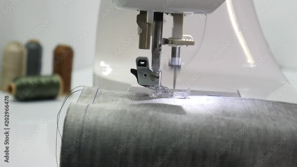 Closeup of moving needle of sewing machine Closeup of moving needle of sewing machine