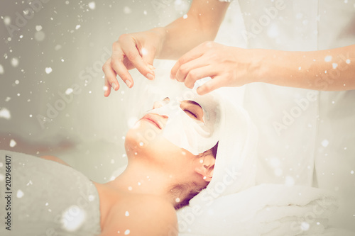 Snow against beautiful brunette getting a facial treatment