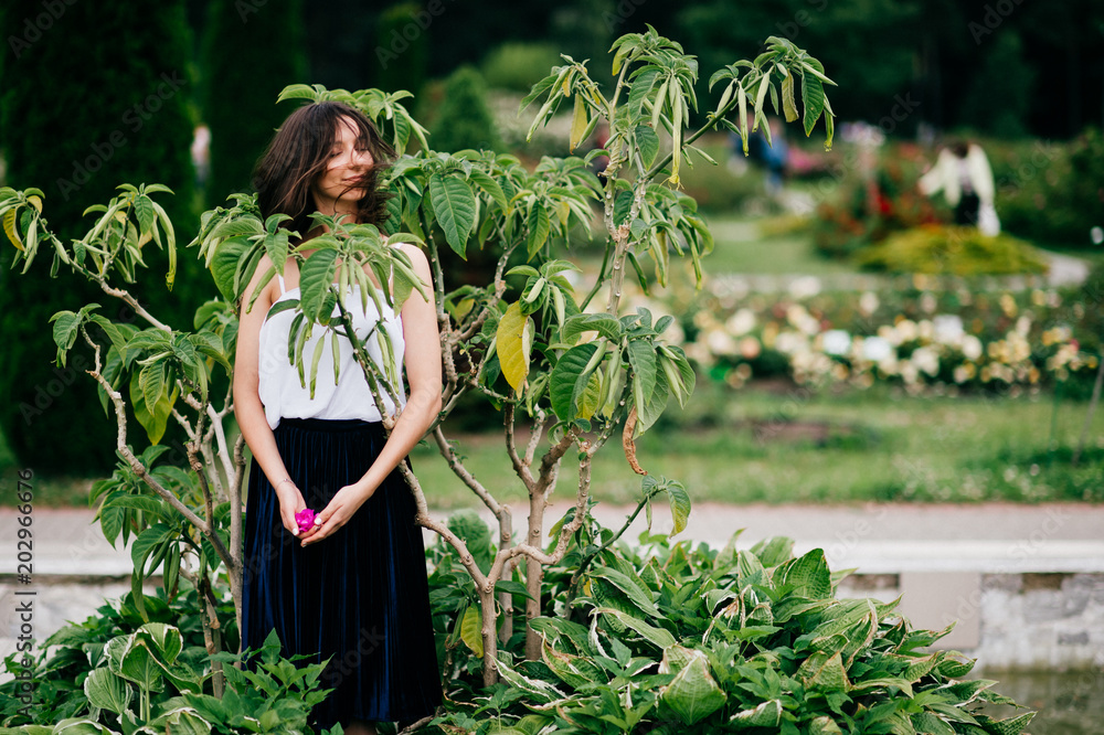 Φωτογραφία Passionate young odd long hair brunette girl with rose flower in hand outdoor portrait