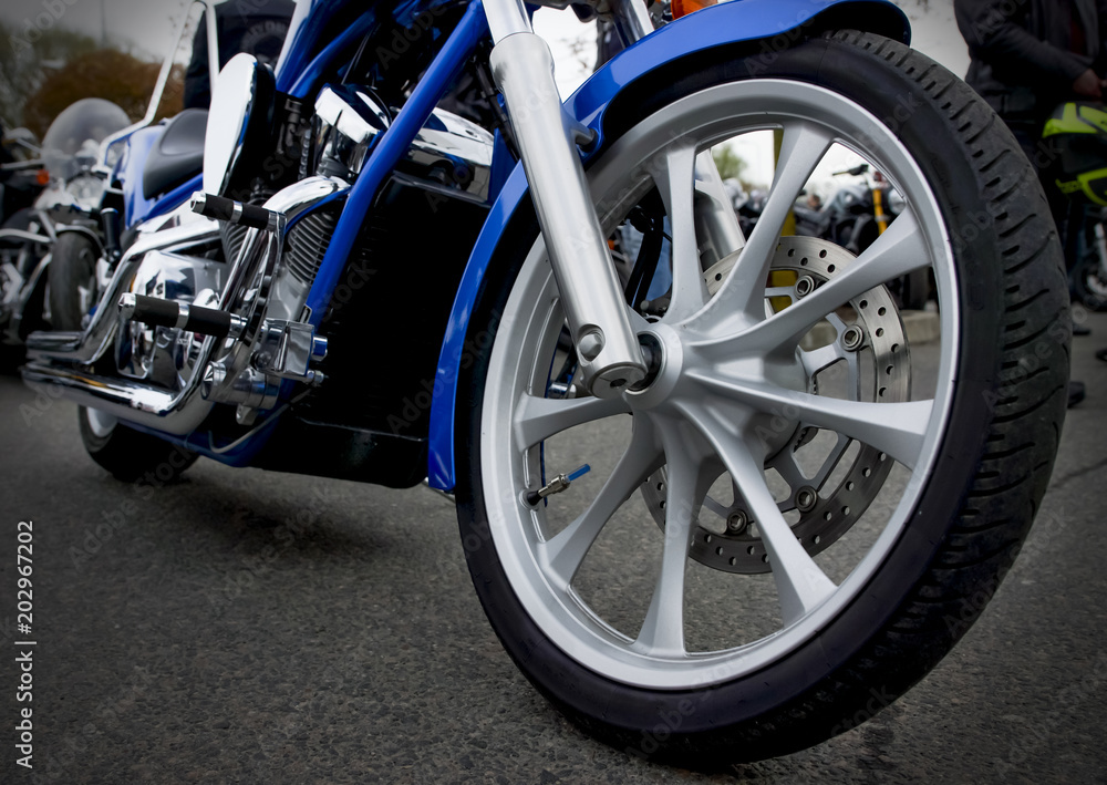 Detailed view of motorbike front wheel with disc break and tire. Detailed view of motorbike front wheel with disc break and tire.