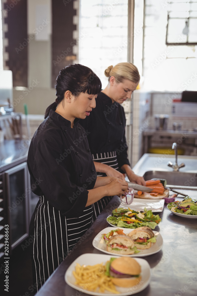 Female chefs preparing food in kitchen