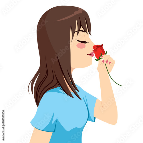 Beautiful young brunette woman holding red rose flower in front of nose smelling scent