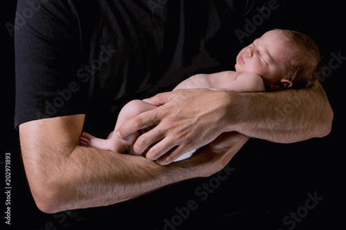 Newborn baby in his father's arms