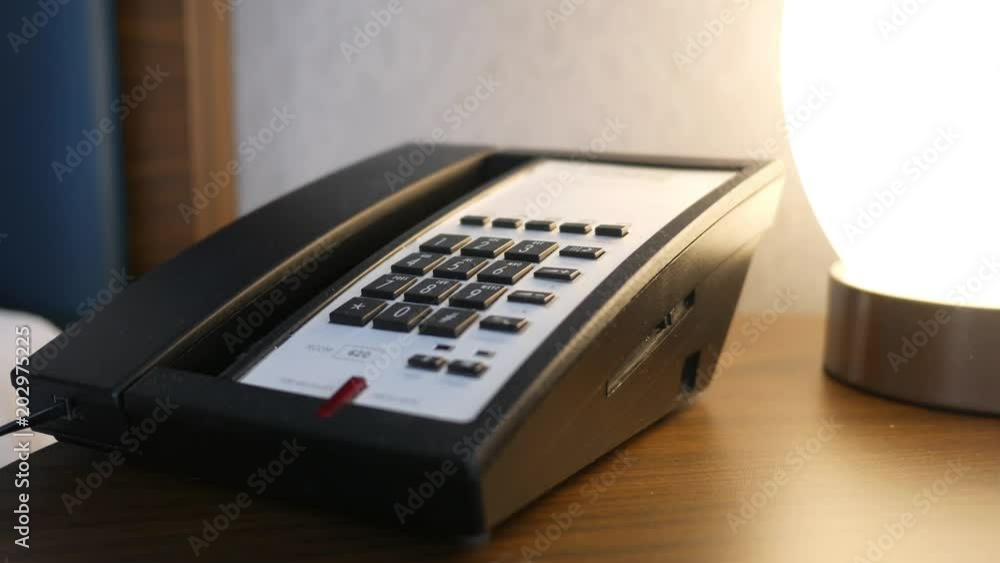 Man hangs up a corded landline modern telephone Man hangs up a corded landline modern telephone
