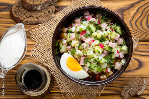 Traditional summer Russian cold soup with kvass, okroshka with ham and vegetables