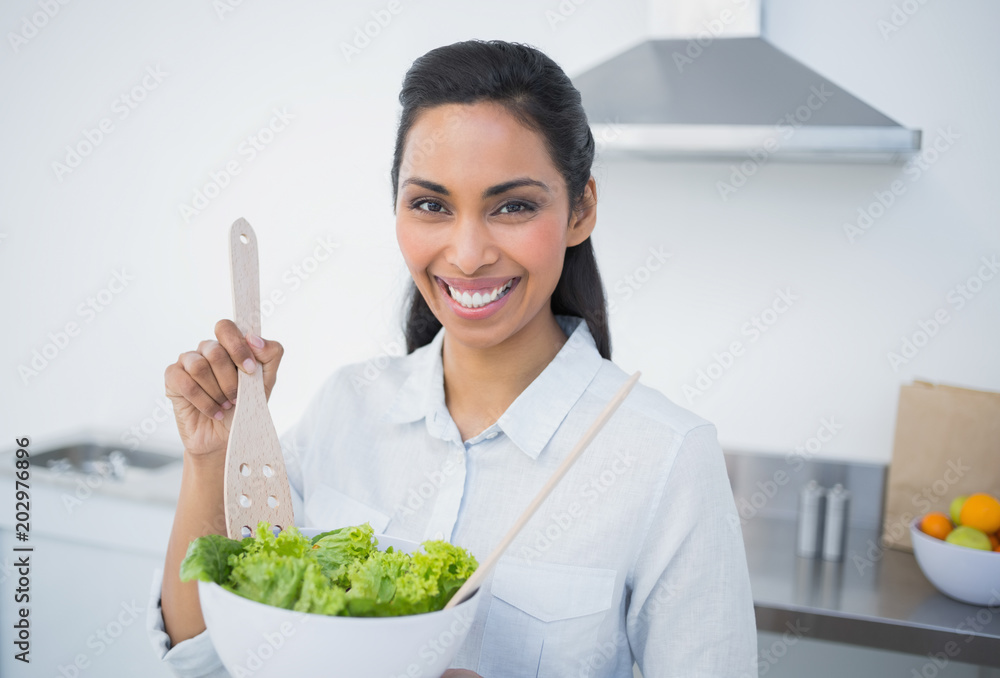 Beautiful smiling woman showing salad smiling at camera Beautiful smiling woman showing salad smiling at camera