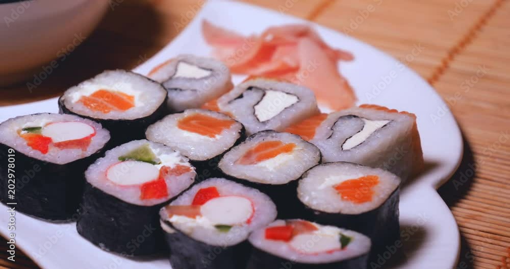 Fresh sushi, Philadelphia cheese, crab sticks, salmon, rice, ginger, soy, orange background, macro. Fresh sushi, Philadelphia cheese, crab sticks, salmon, rice, ginger, soy, orange background, macro.