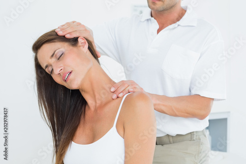 Male chiropractor doing neck adjustment photo