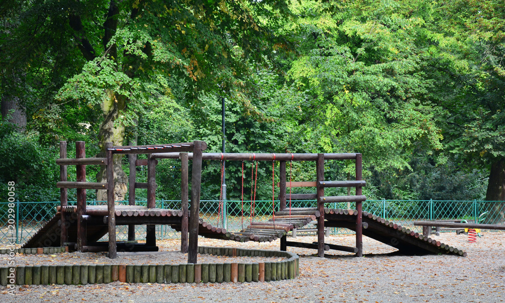 Polish wooden playground in the park / Dark wooden playground with a fence in the park
Polish wooden playground in the park / Dark wooden playground with a fence in the park