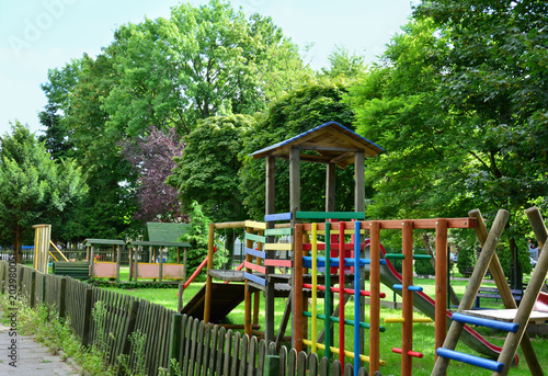 Colourful wooden playground in the park / Colourful wooden playground with a fence in the park 
