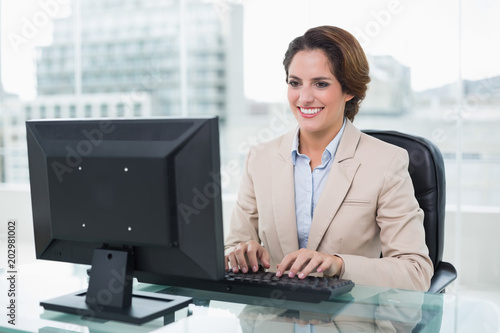 Cheerful businesswoman sitting in front of computer