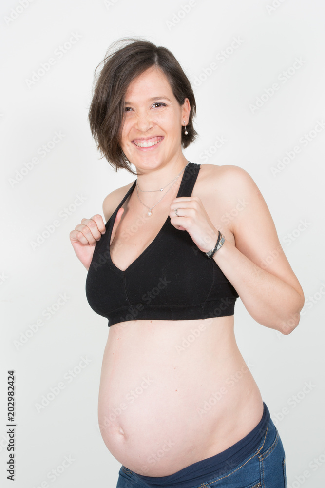 A pregnant woman in fitness clothes pregnancy belly on white background A pregnant woman in fitness clothes pregnancy belly on white background