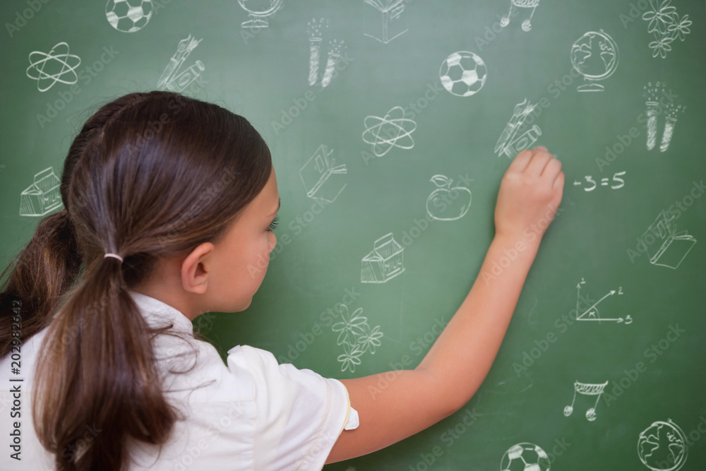 School doodles against cute pupil writing on chalkboard School doodles against cute pupil writing on chalkboard