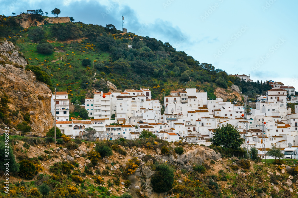 White Andalusian village - pueblo blanco - in the mountain range in Casares during sunset