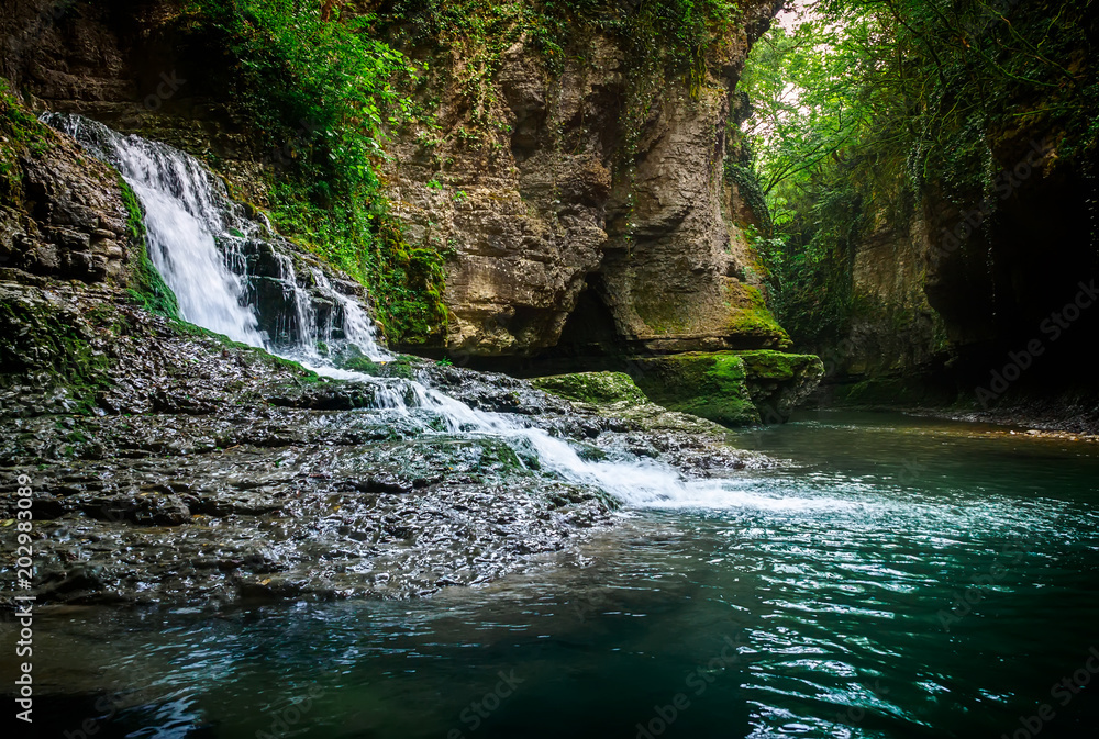 Amazing forest waterfall flowing into the cold mountain river. Martvili canyon. Nature fall Amazing forest waterfall flowing into the cold mountain river. Martvili canyon. Nature fall