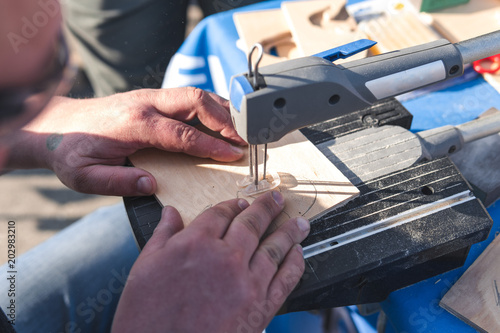 Scroll Saws, man hand Carpenter cutting wooden plank with electric saw, stationary, small electrical saws, mainly used by hobbyists for cutting out intricate shapes