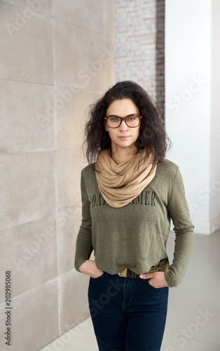 Portrait of woman in glasses standing indoors