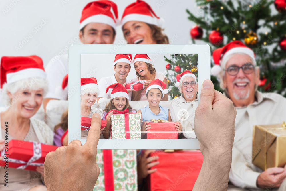 Composite image of hand holding tablet pc showing photograph Composite image of hand holding tablet pc showing photograph
