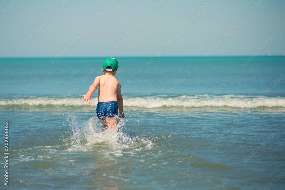 Little boy is running along the beach