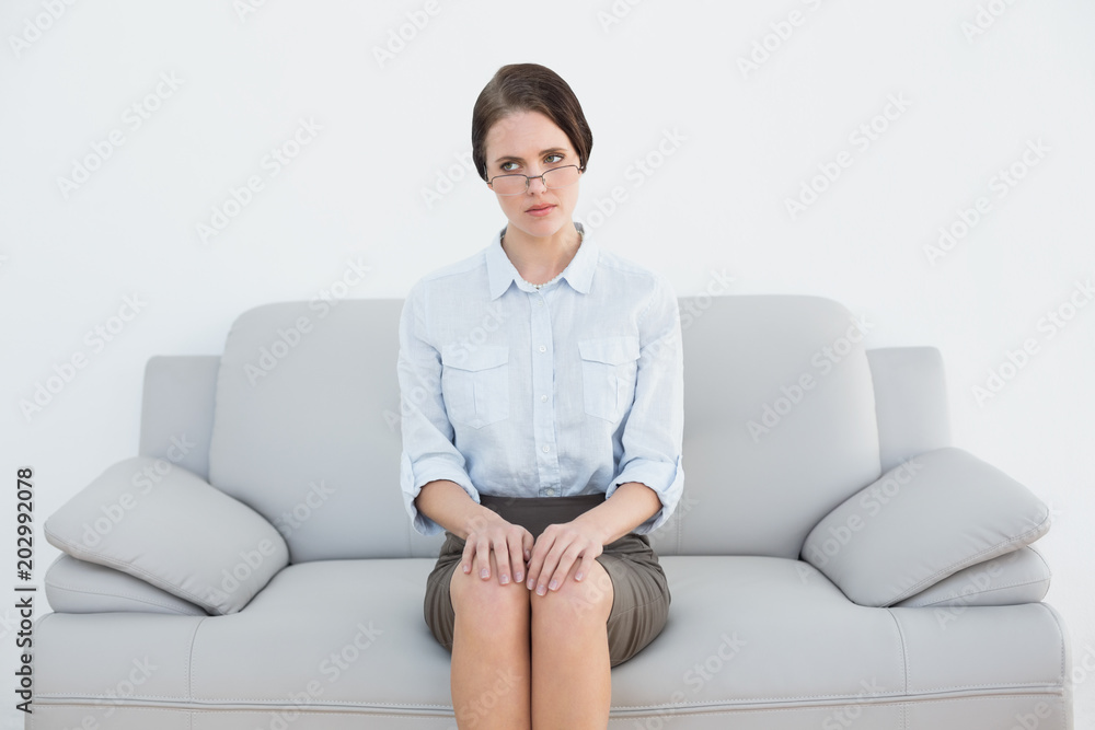 Displeased well dressed woman sitting on sofa Displeased well dressed woman sitting on sofa
