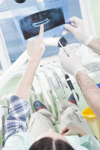 Dentist showing dental x-ray to the patient