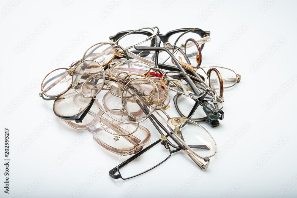 Group of old broken eyeglasses on white background. Concept - replace your old glasses Group of old broken eyeglasses on white background. Concept - replace your old glasses