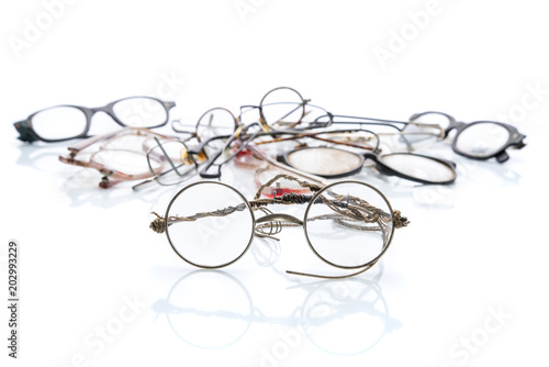 Vintage broken eyeglasses isolated on white background, with shadows and reflection