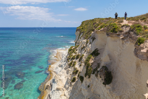 Beautiful azure turquoise Mediterranean sea and white chalk limestone cliffs of St Thomas Bay, walking, trekking, hiking along the Munxar Path, Marsaskala, Malta photo