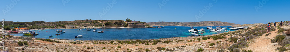 High Resolution Panorama of the crystal clear blue waters of Santa Maria Beach in Santa Marija Bay, a large quiet bay on the small holiday island of Comino, Malta, June 2017
