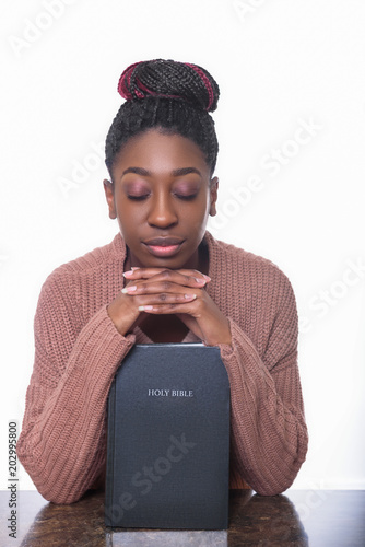 Cuadro en lienzo A young African American woman praying over the Holy Bible