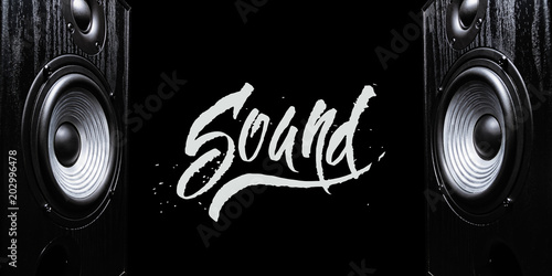 Two sound speakers with hand-drawn word SOUND between them on black background. photo