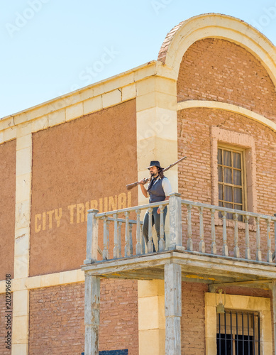 West sheriff guarding the prison with a shotgun on the second floor of the building photo