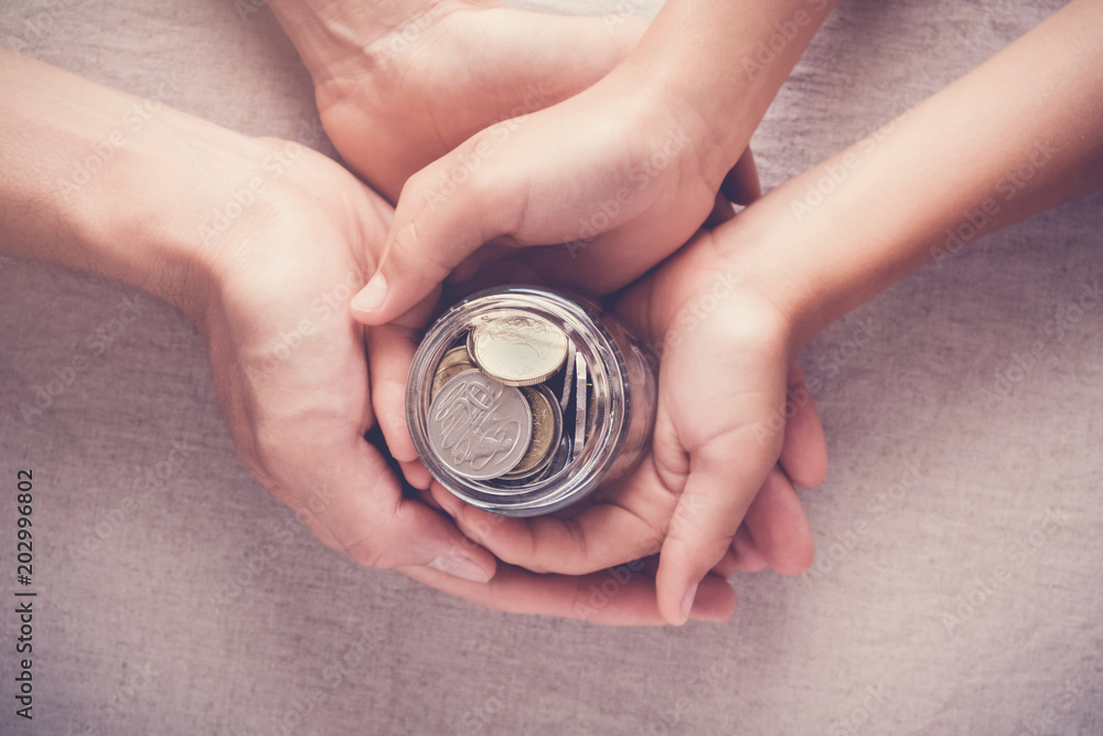 Φωτογραφία child and adult holding money jar, donation, saving, charity, family finance pla