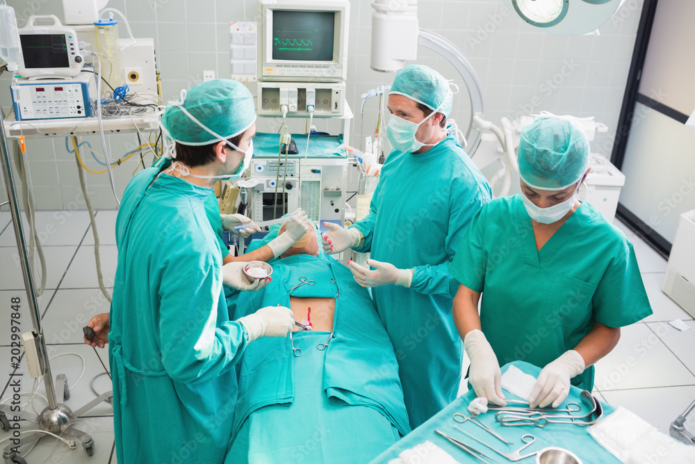 Team of surgeons operating an uncounscious patient Team of surgeons operating an uncounscious patient