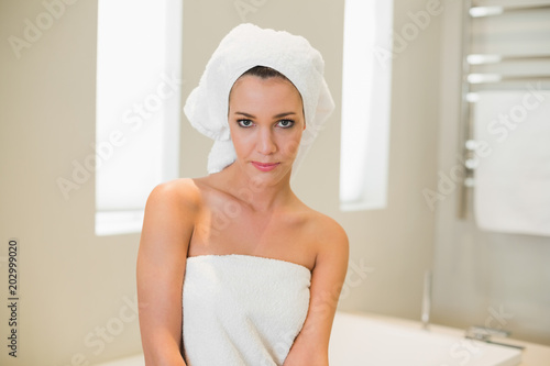 Stern natural brown haired woman preparing for her shower