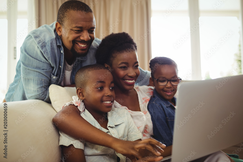 Parents and kids using laptop in living room Parents and kids using laptop in living room