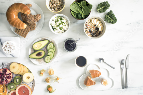 Enjoy healthy breakfast. Top view of different vegetarian food on the white marble table background.