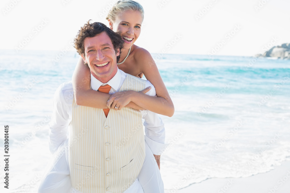 Blonde bride getting a piggy back from new husband Blonde bride getting a piggy back from new husband
