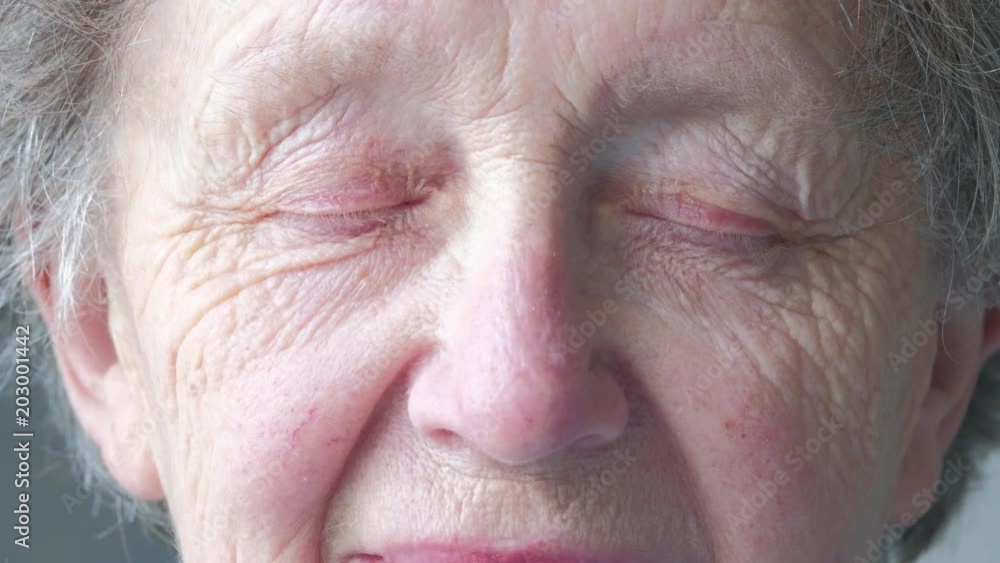 Close up portrait of an elderly caucasian woman opening her eyes Close up portrait of an elderly caucasian woman opening her eyes
