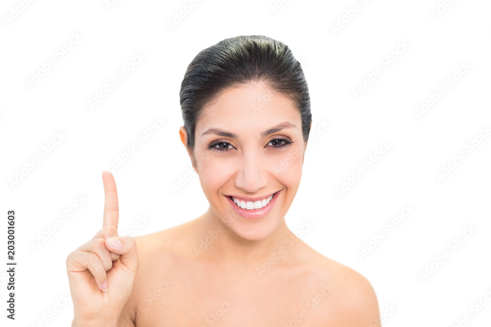 Smiling brunette pointing up with one hand Smiling brunette pointing up with one hand