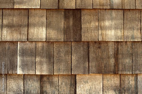 Old wooden roof background texture. Aged brown color tiles as a roofing material on a house ceiling.